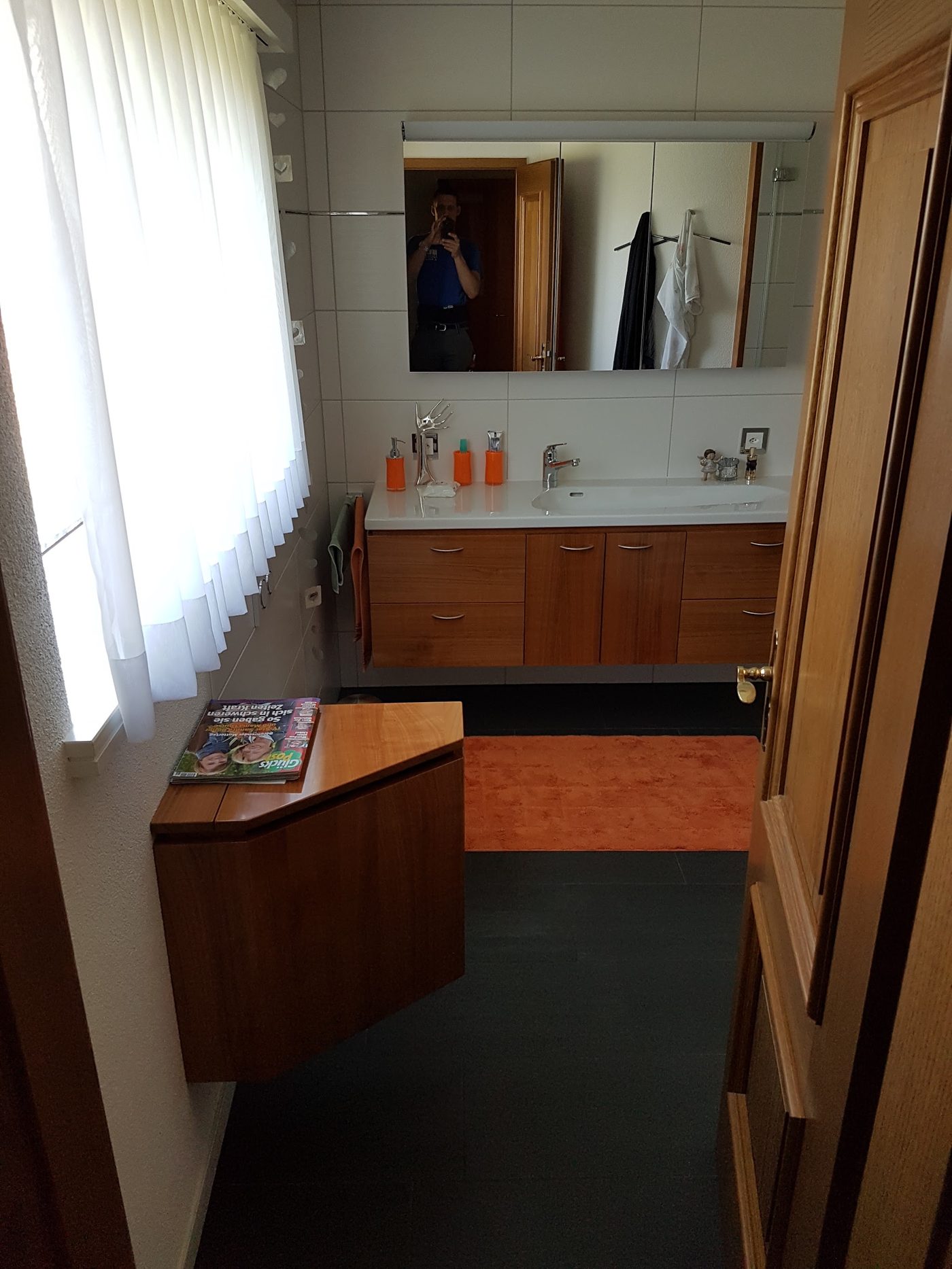 Badezimmer mit Holz-Waschtisch und Spiegel, fertig saniert